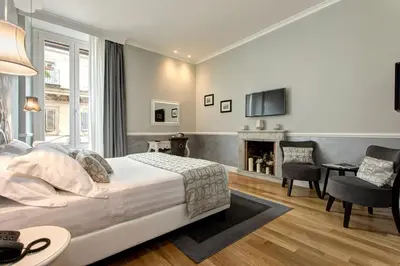 a bedroom with a bed and a living room at Relais de l'Opera Luxury Rooms in Rome