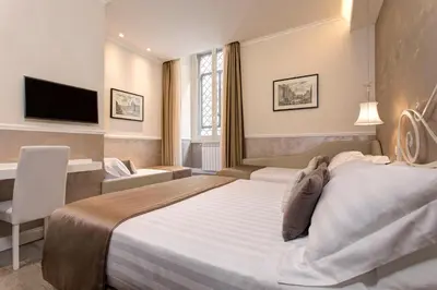 a hotel room with a large bed and a television at Relais de l'Opera Suites in Rome
