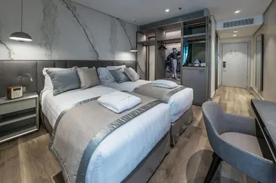 a bedroom with two beds and a table and chairs at The Regency, Rome, a Tribute Portfolio Hotel in Rome