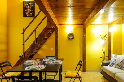 a dining room with a table and a yellow wall at Wood Easy Flat in Rome