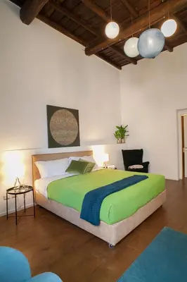 a bedroom with a large green bed and a chair at Palazzetto de Lante Appartamento Parione in Rome
