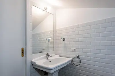 a white bathroom with a toilet and a sink at Trevi Fountain Stylish Penthouse IREX Apartment in Rome
