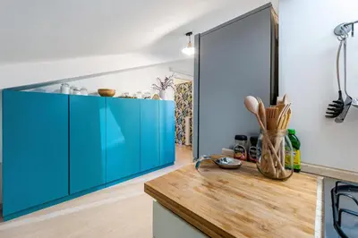 a kitchen with blue cabinets and a mirror at Trevi Fountain Stylish Penthouse IREX Apartment in Rome