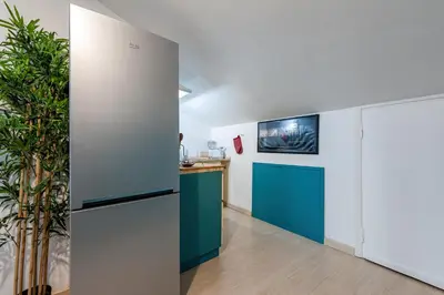 a kitchen with blue and white cabinets and a tv at Trevi Fountain Stylish Penthouse IREX Apartment in Rome