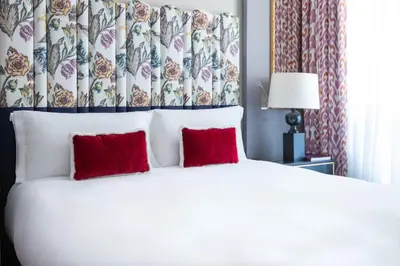 a bedroom with a white bed with red pillows at Maalot Roma - Small Luxury Hotels of the World in Rome
