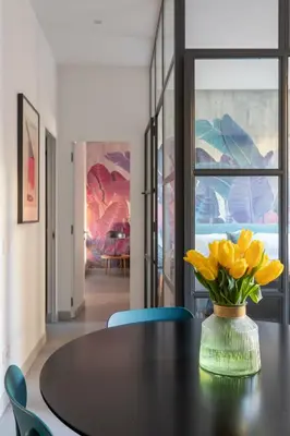 a black table with yellow flowers in a vase on it at Twin Flowers apartment in San Giovanni in Rome
