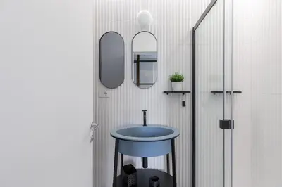 a bathroom with a blue sink and two mirrors at Twin Flowers apartment in San Giovanni in Rome