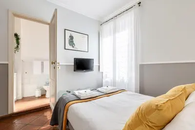 a white bedroom with a bed and a bathroom at Rome As You Feel - Paradiso Apartment in Rome