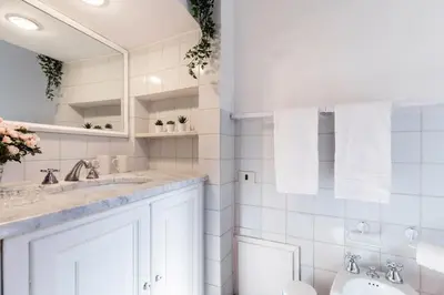 a white bathroom with a sink and a toilet at Rome As You Feel - Paradiso Apartment in Rome