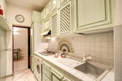 a kitchen with a sink and a clock on the wall at FRESH HOUSE CAVOUR in Rome