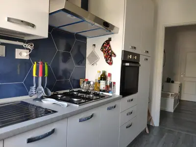 a kitchen with white cabinets and a stove top oven at Casa Giustiniano - Metro San Paolo in Rome