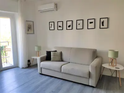 a living room with a white couch and two tables at Casa Giustiniano - Metro San Paolo in Rome