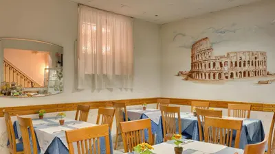 a restaurant with tables and a picture of the coliseum at Hotel Washington in Rome
