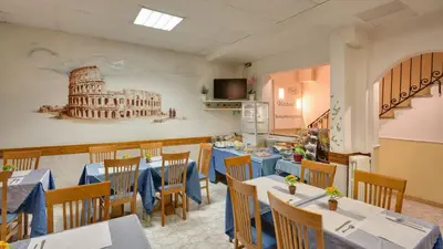 a restaurant with tables and chairs and a picture of the coliseum at Hotel Washington in Rome