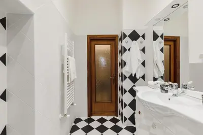 a bathroom with a black and white checkered wall at My Home in San Pietro in Rome