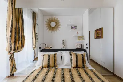 a bedroom with a bed with a mirror on the wall at My Home in San Pietro in Rome