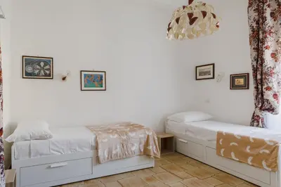 two beds in a room with white walls at My Home in San Pietro in Rome