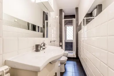 a white bathroom with a sink and a toilet at BBHOME Comfort apartment near Colosseum in Rome
