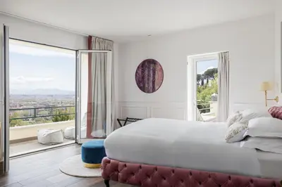 a white bedroom with a large bed and a large window at Monastero dei Santi in Rome