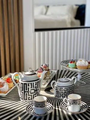 a table with two tea pots and plates of desserts at Monastero dei Santi in Rome