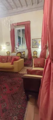 a living room with two couches and red curtains at Residenza al Pantheon - RH Collection in Rome