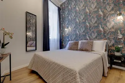 a bedroom with a bed with a floral wallpaper at The Venue Sistina in Rome