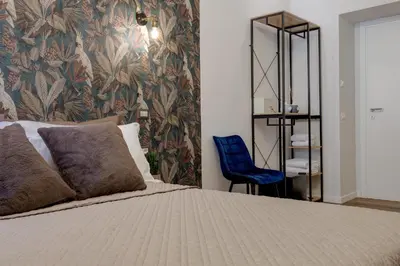 a bedroom with a bed and a blue chair at The Venue Sistina in Rome