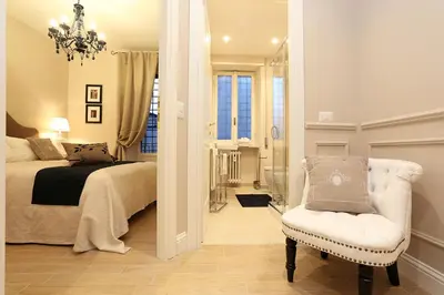 a bedroom with a bed and a chair and a mirror at Daplace - Lucrezia Apartment in Rome