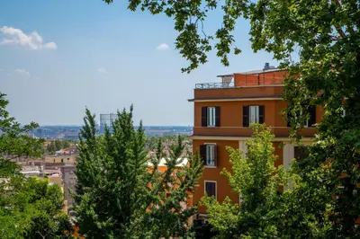 a building in a city with trees in the foreground at Daplace - Terenzia Apartment in Rome