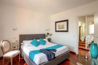 a bedroom with a large bed with blue pillows at Daplace - Terenzia Apartment in Rome