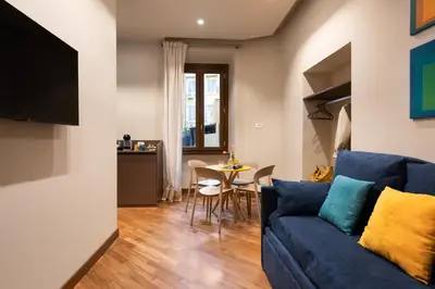 a living room with a blue couch and a table at Circle in the Square in Rome