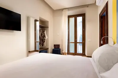 a bedroom with a white bed and a large window at Circle in the Square in Rome