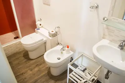 a white bathroom with a toilet and a sink at Relais Cola Di Rienzo in Rome