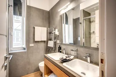 a bathroom with a sink and a toilet and a mirror at Maison Ripetta in Rome