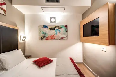a bedroom with a bed and a painting on the wall at Maison Ripetta in Rome