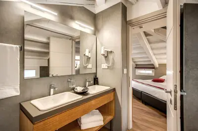 a bathroom with a sink and a mirror and a bed at Maison Ripetta in Rome