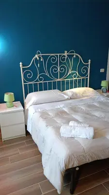a bedroom with a large bed with a blue wall at Colombo Holidays APT in Rome