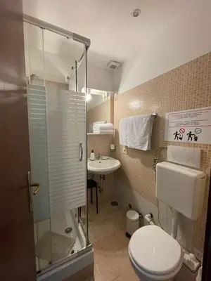 a bathroom with a toilet and a shower and a sink at Guest House Meret in Rome