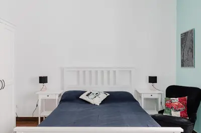 a bedroom with a bed and two white tables at Scarfoglio Apartment, 4 persone, 2 camere, balcone, Wi-Fi, Stazione Tiburtina in Rome