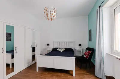 a bedroom with a bed and a desk and a chair at Scarfoglio Apartment, 4 persone, 2 camere, balcone, Wi-Fi, Stazione Tiburtina in Rome