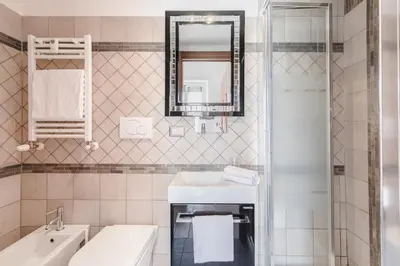 a white bathroom with a sink and a mirror at Casa Flo in Rome