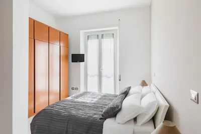 a white bedroom with a bed and a window at Casa Flo in Rome
