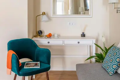 a living room with a green chair and a desk at Momo Central Rome 2 in Rome