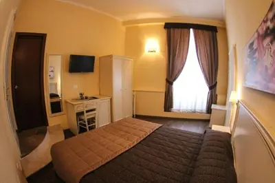 a bedroom with a bed and a desk and a window at La Favola di San Pietro in Rome