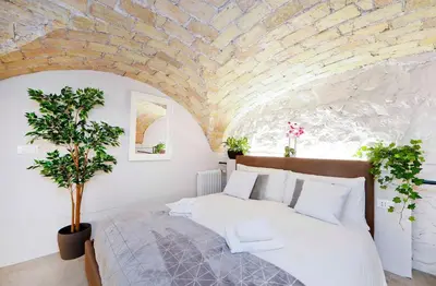 a bedroom with a large bed with a stone wall at Post Industrial Loft Trastevere - Top Collection in Rome
