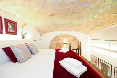 a bedroom with a white bed with a red blanket at Sky Dream Loft Trastevere in Rome