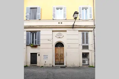 a white building with a brown door and windows at Bright Cozy Studio Trastevere in Rome