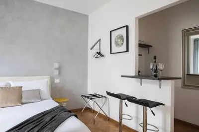 a bedroom with a bed and a table and two stools at Silver Luxury Jacuzzi Suite Trastevere in Rome