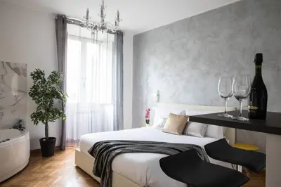 a bedroom with a bed with wine glasses and a bathtub at Silver Luxury Jacuzzi Suite Trastevere in Rome