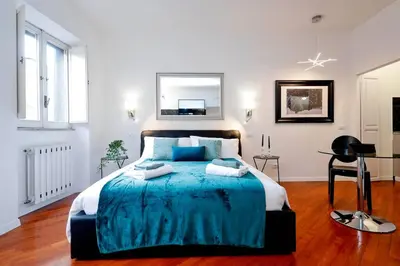 a bedroom with a large bed with a blue blanket at Pantheon Amazing Jacuzzi Suite in Rome